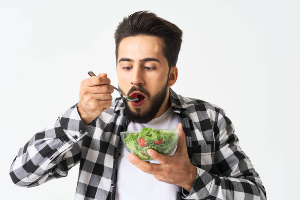 man in plaid shirt eating salad healthy food - Foto, imagen