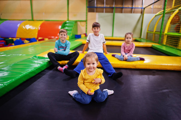 Kids playing in indoor play center and sitting on a trampoline. Large family with four children. - 写真・画像