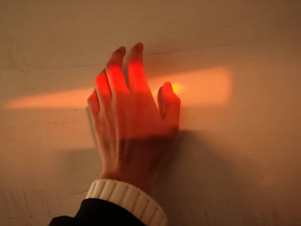 hand with a red and yellow painted wall with a blurred background - Φωτογραφία, εικόνα