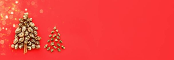 New Year and Christmas card. Two decorative Christmas tree made from golden cones on a red background. Banner - Fotoğraf, Görsel