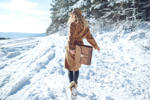 Een vrouw reist in de winter. Mooi meisje in de winter in de natuur. - Foto, afbeelding