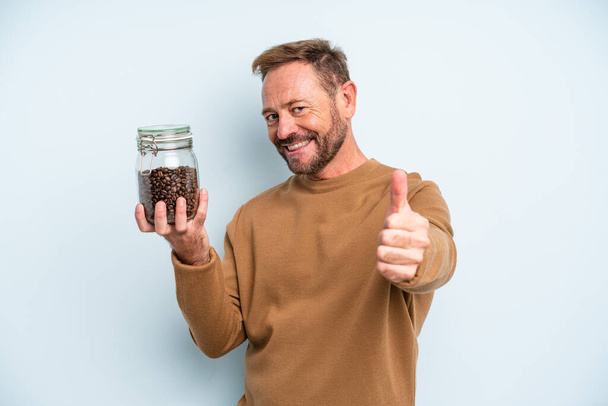 middle age man feeling proud,smiling positively with thumbs up. coffee beans concept - Zdjęcie, obraz