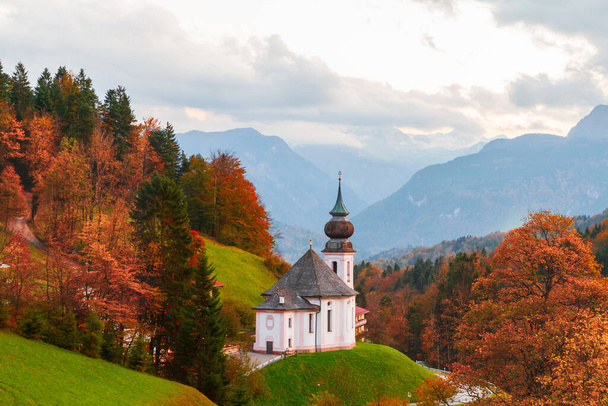 Iglesia de María Gern en las montañas en el fondo con la montaña Watzmann en los colores de otoño al atardecer, Baviera, Berchtesgaden en Alemania - Foto, imagen