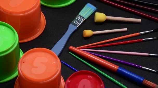 Επιλογή παιδικών πινέλων τέχνης και χειροτεχνίας, φλυτζανιών και σφουγγαριών διαφόρων χρωμάτων - Πλάνα, βίντεο