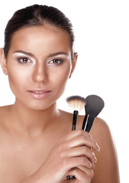 Portrait of young adult woman applying blusher - Foto, imagen