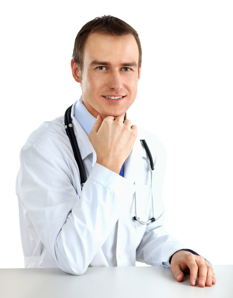 Portrait of a doctor sitting at the desk on white background - Photo, Image