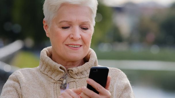 Closeup gray-haired Mature woman texting messaging on modern smartphone gadget, scrolling, touching screen, surprised, grandmother browse internet on cellphone, comments video using ordering online - Fotoğraf, Görsel