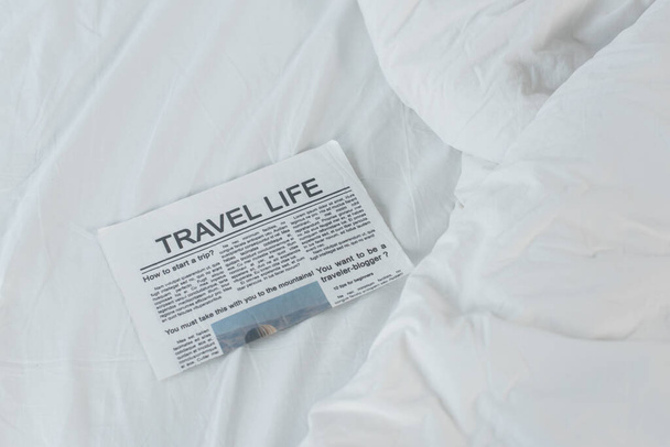 korkea kulma näkymä matkustaa elämän sanomalehti valkoisella sängyllä  - Valokuva, kuva