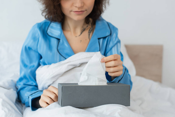 cropped view of tattooed woman reaching napkin in tissue box - Photo, Image