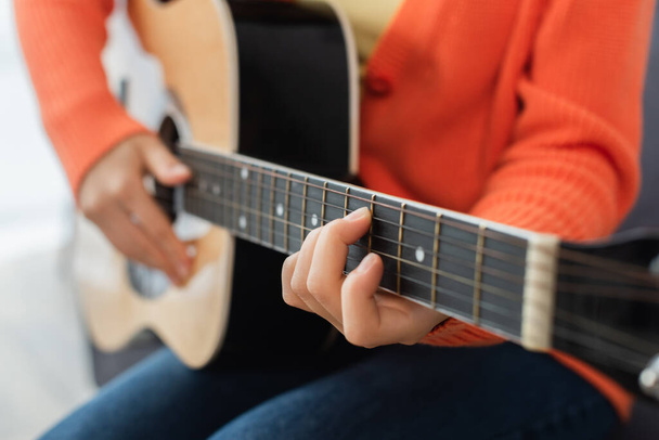 vue recadrée de jeune femme jouant de la guitare acoustique à la maison - Photo, image