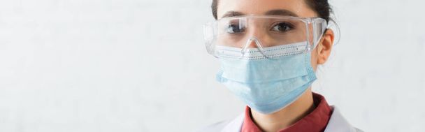 brunette scientifique en lunettes et masque médical regardant la caméra en laboratoire, bannière - Photo, image