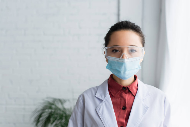 barna tudós szemüveg és orvosi maszk nézi kamera a laborban - Fotó, kép