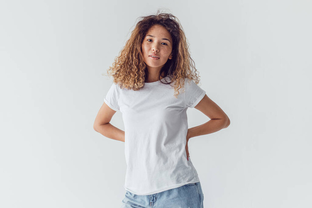 Attractive woman with lush curly hair wearing a white t-shirt. Mock-up. - Фото, зображення