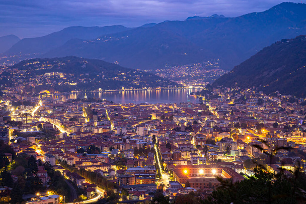 The city of Como, and the lake, photographed after sunset, with the mountains of Brunate, Castel Baradello, and the mountains overlooking the lake. - Photo, Image