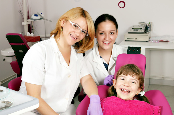 niña feliz paciente con dentista y enfermera
 - Foto, Imagen