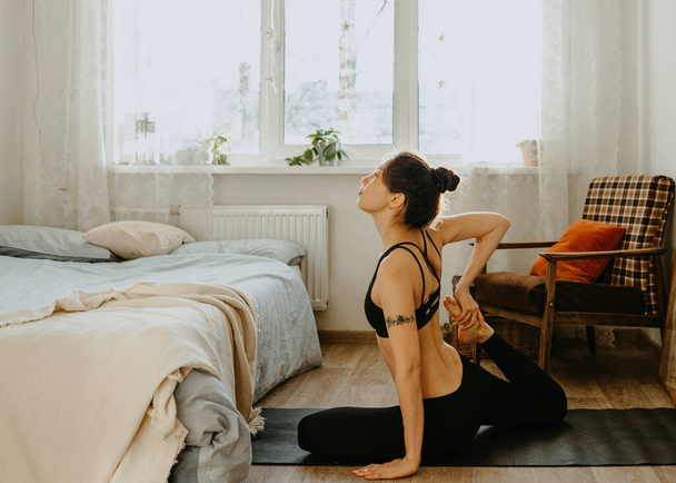 Женщина практикует йогу дома - Фото, изображение