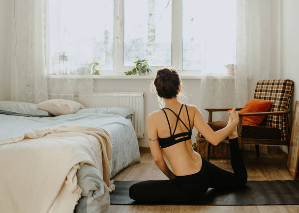 woman practicing yoga at home - Foto, afbeelding