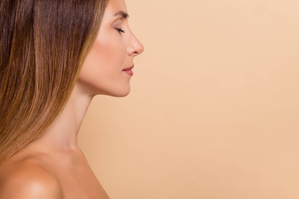 Cropped profile side view portrait of attractive dreamy peaceful woman copy space advert cosmetic isolated over beige pastel color background. - Foto, Bild