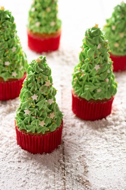 Weihnachtsbaum Cupcakes auf Schnee Holztisch - Foto, Bild