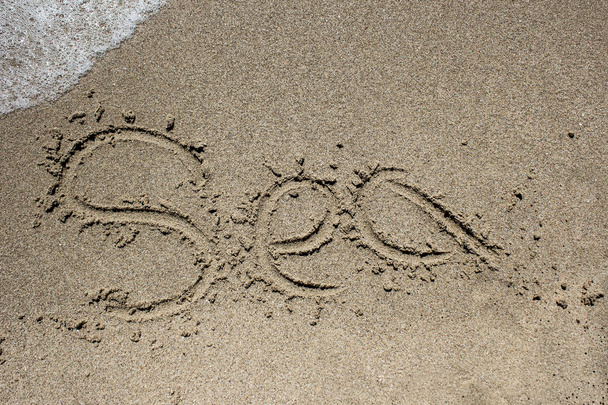 Word beach written on sand with wave coming - Foto, Imagem