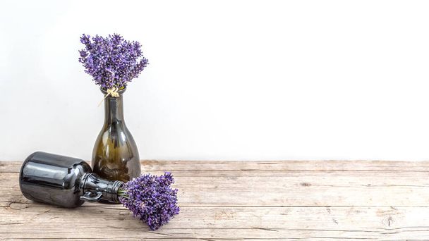 Many bouguet of violet purple lavendula lavender flowers herbs in old brown vases (pharmacy bottle), on white background and wooden table banner panoramic panorama long, close up - Photo, Image