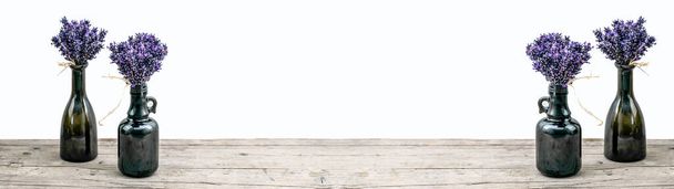 Molti bouguet di viola lavendula viola lavanda fiori erbe in vecchi vasi marroni (bottiglia farmacia), su sfondo bianco e banner tavolo in legno panorama panoramico lungo, da vicino - Foto, immagini