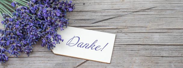 Primo piano di bouguet di viola lavendula viola lavanda fiori erbe con ciondolo in legno con la parola: "Grazie", su vecchio tavolo in legno rustico, sfondo in legno banner panorama - Foto, immagini