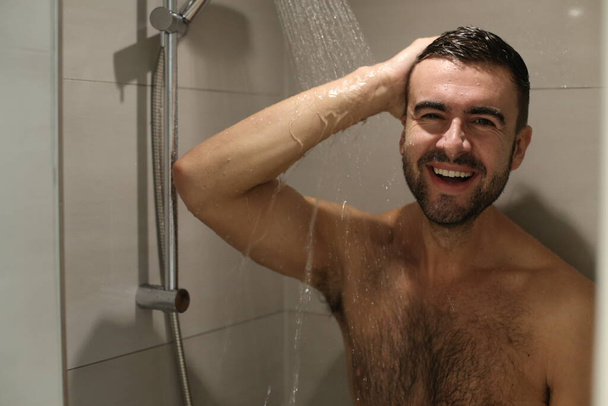 portrait of handsome young shirtless man taking shower - Фото, зображення