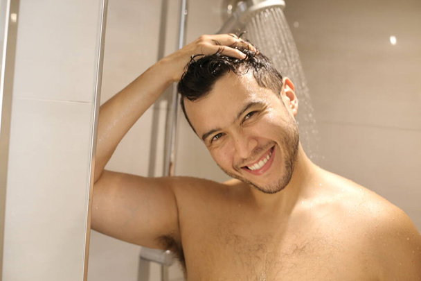 retrato de un joven guapo sin camisa tomando una ducha - Foto, imagen