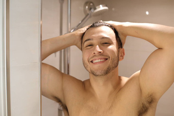 retrato de un joven guapo sin camisa tomando una ducha - Foto, Imagen