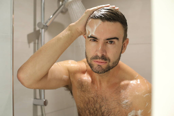 portrait de beau jeune homme torse nu prenant une douche - Photo, image