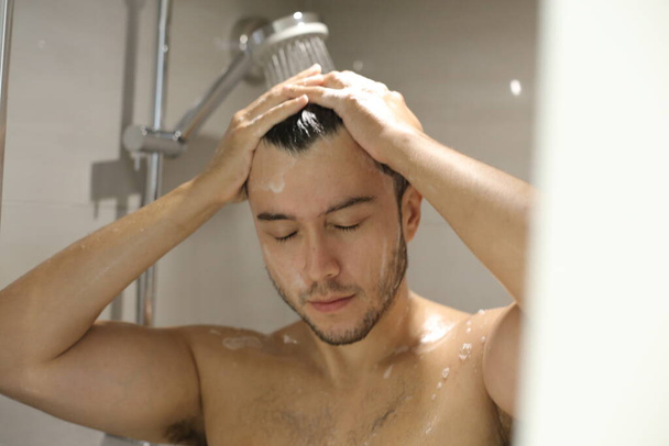 portrait de beau jeune homme torse nu prenant une douche - Photo, image