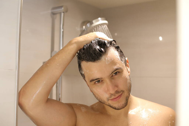 portrait of handsome young shirtless man taking shower - Фото, изображение