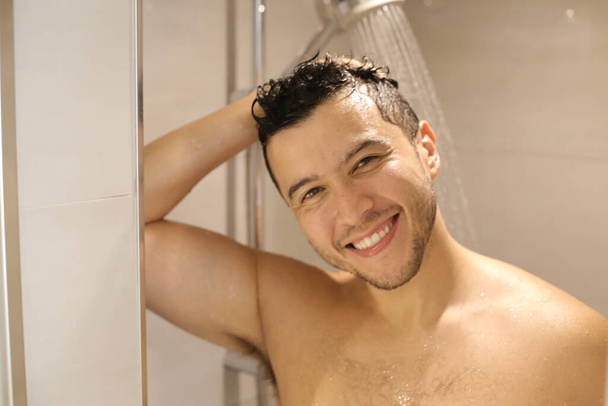 portrait of handsome young shirtless man taking shower - Фото, изображение