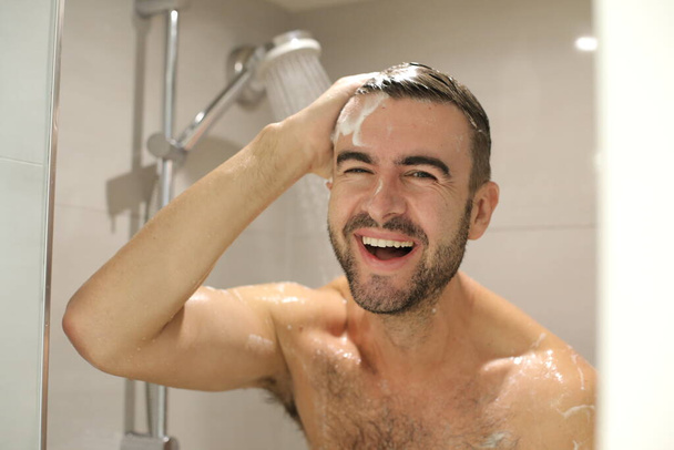 portrait of handsome young shirtless man taking shower - Photo, Image