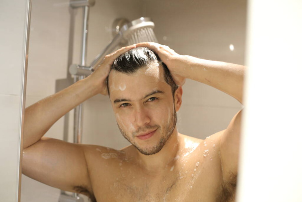 portrait of handsome young shirtless man taking shower - Foto, Imagem