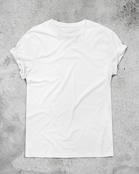 White t-shirt on concrete floor - Фото, изображение