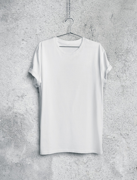 White t-shirt on concrete wall - Фото, изображение