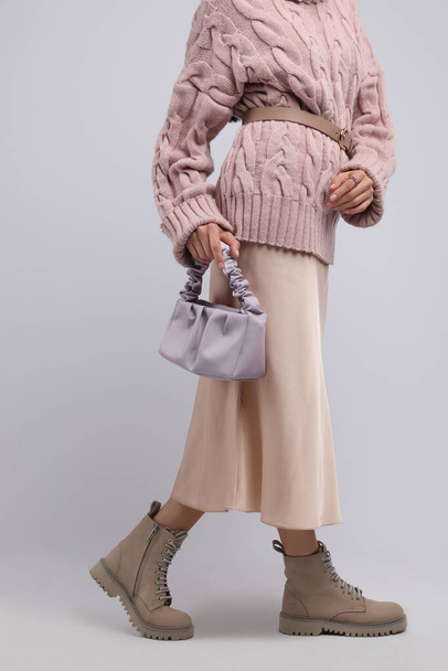 Fashionable woman with stylish bag on light background, closeup - Valokuva, kuva