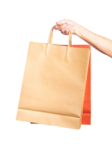 Close-up of hand senior woman holding paper bags with white background. Space for text. - Photo, Image