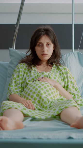 Portret van een zwangere vrouw in het ziekenhuisbed - Foto, afbeelding