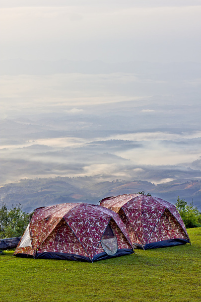 camping tent in valley in de ochtend met mist. - Foto, afbeelding