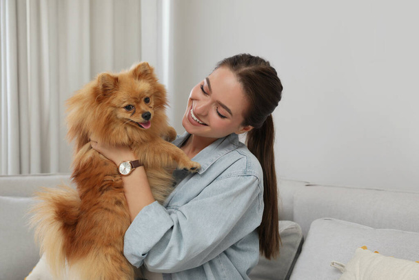 Happy young woman with cute dog at home - Foto, afbeelding