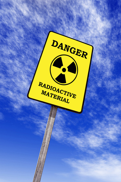 Radioactivity billboard on a blue sky with clouds - Photo, Image