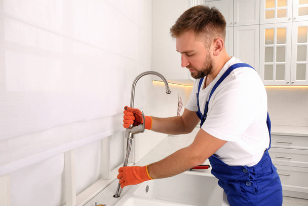 Professional plumber repairing water tap in kitchen - Fotografie, Obrázek