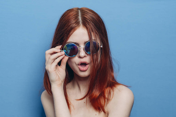 attractive woman with bare shoulders fashionable glasses blue background - Fotó, kép