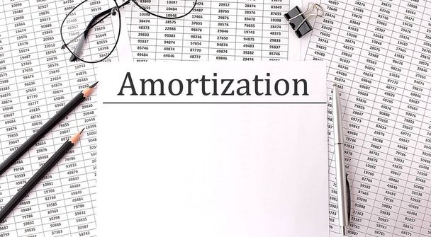 Paper with AMORTIZATION on table with chart and pencils - Photo, Image