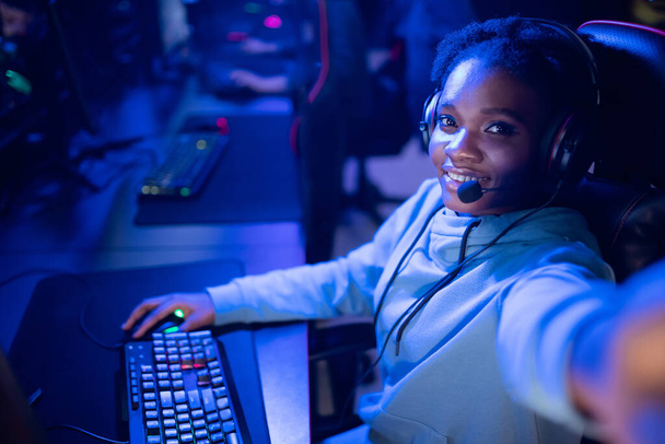 Streamer beautiful African American girl make selfie photo professional gamer playing online games computer, neon color - Photo, Image