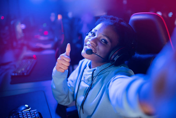 Streamer African gamer américaine belle femme faire selfie photo jouer à des jeux en ligne ordinateur, couleur néon - Photo, image