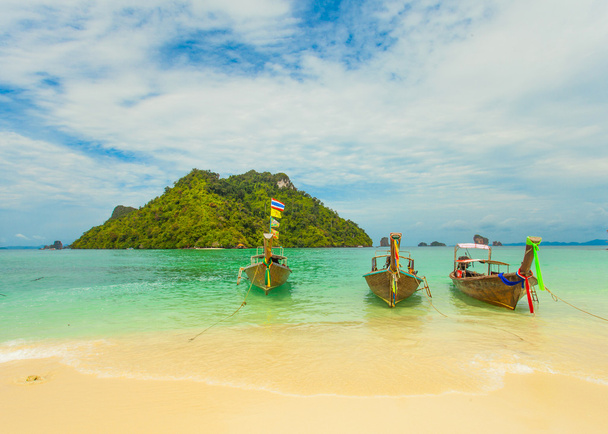 Barco tailandés tradicional de cola larga con isla tailandesa en el fondo
 - Foto, imagen